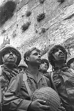 Israeli paratroopers reverently reach the Western Wall on 7 June 1967