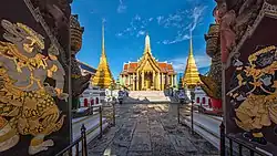 A Thai temple complex with several ornate buildings, and a lot of visitors