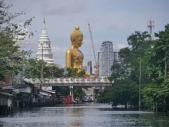 Buddha image covered with scaffolding and with a crane next to it.