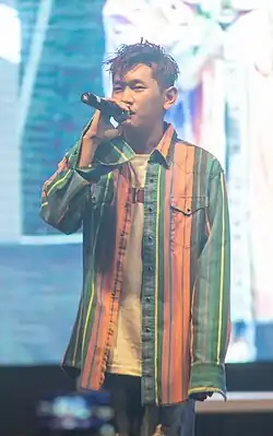 Crush sings into a microphone.