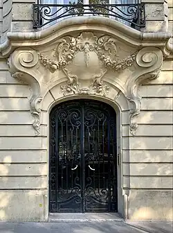 Rococo Revival volutes above the door of Avenue Kléber no. 47bis, Paris, unknown architect, 1908[12]