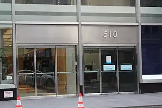 The main entrance on 43rd Street, a set of metal-and-glass doors within a glass facade