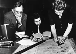 Three individuals working on a map of cultural treasures in war areas at the Frick Art Reference Library, 1943-1944.