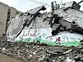 A mural featuring Handala on rubble from a destroyed building in Gaza City; the text reads 'There is hope' in Palestinian Arabic