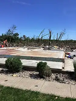 EF4 damage example--Well-built homes are reduced to a short pile of medium-sized debris on the foundation. Homes with poor or no anchoring are swept completely away. Large, heavy vehicles, including airplanes, trains, and large trucks, can be pushed over, flipped repeatedly, or picked up and thrown. Large, healthy trees are entirely debarked and snapped off close to the ground or uprooted altogether and turned into flying projectiles. Passenger cars and similarly sized objects can be picked up and flung for considerable distances.