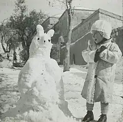 Young girl looking at a snowman in Jerusalem in approximately 1934