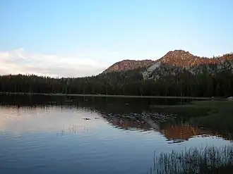 Early morning or evening photo of the the lake reflecting a mountain.