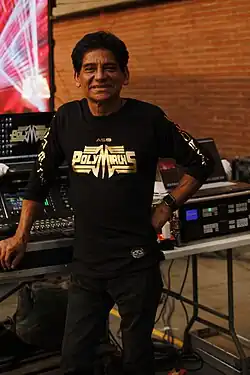 Apolinar Silva de la Barrera, the founder of Polymarchs, poses for a photo as he stands in front of a board.