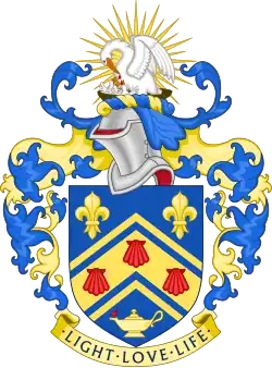Arms of Southlands College. Shield: Azure, on a chevron cotised between in chief two fleurs-de-lys and in base a lamp Or inflamed proper, three escallops gules; crest: On a wreath of the colours, In front of a demi sun Or a pelican in her piety proper; motto: Light, love, life.