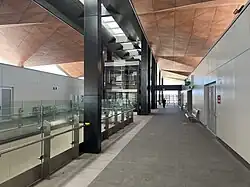 A covered station concourse with lifts to the platform below