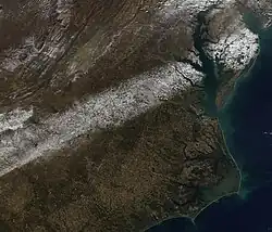 A satellite image shows a narrow band of fallen snow across several states in the eastern and southeastern United States, which was taken on December 11.