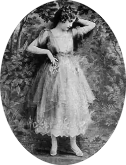 Black and white film still showing a woman in an elegant dress
