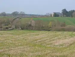 A few buildings scattered amongst fields and trees.