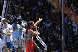 A TV Bahia cameraman films a woman singing on a stage