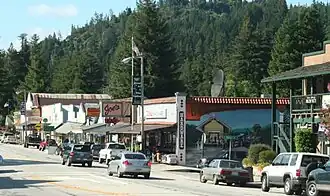 Looking north from Highway 9 at the Boulder Creek Hardware building and the 70-foot-long (21&nbsp;m) painted mural by John Ton, depicting two phases of the community's history