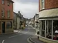 A view down a central high street, surrounded by shops on both sides.
