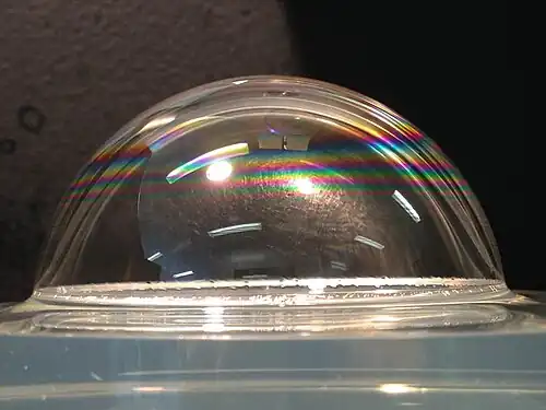 A soap bubble wetting a liquid surface