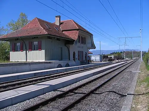 Two side platforms next to a two-story station building
