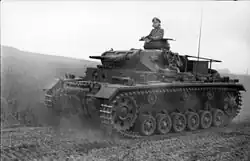 A black and white photograph of a moving tank