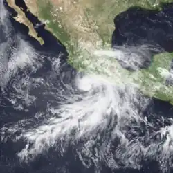 A satellite image of a hurricane near the western coast of Mexico; the cloud pattern resembles a spiral near the center, with an elongated hook curving outwards