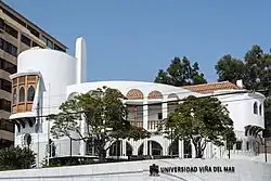 A white, rounded building with red Spanish tile roof