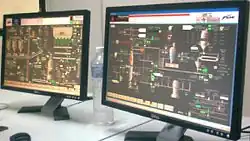 Two computer flat screens showing a plant process management application