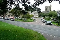 Looking to the junction of Front Street (B6341), in the foreground running left ro right, and Church Street, this street leads from Town Foot to All Saints church.
