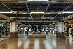 The lower platform level of the station, with escalators leading up to the concourse and the other platform.