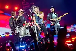 Coldplay onstage with their respective instruments