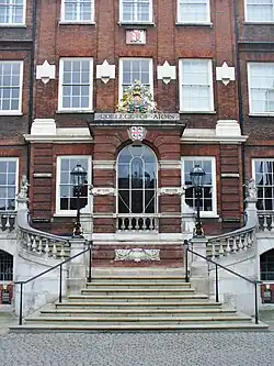 A red brick building in the Georgian style. A staircase at the front leads up to the front door.