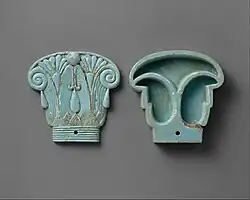 Cosmetic box in the shape of an Egyptian composite capital, its cap being in the left side; 664–300&nbsp;BC; glassy faience; 8.5&nbsp;cm ×&nbsp;9&nbsp;cm (3.3&nbsp;in ×&nbsp;3.5&nbsp;in); Metropolitan Museum of Art