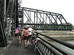 Cyclists on the bridge, waiting for it to close