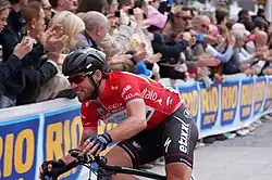A cyclist riding wearing a red jersey