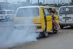 An image of a yellow Danfo bus causing air pollution in Lagos State, Nigeria