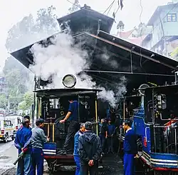 Men standing around a steam locomotive in a shed