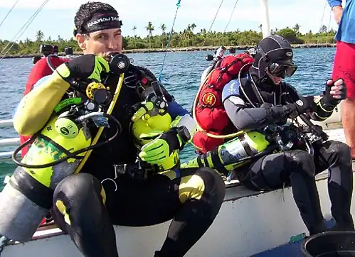 Technical divers preparing for a mixed-gas decompression dive. Note the backplate and wing setup with side mounted stage tanks[broken anchor].