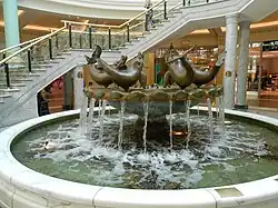A bronze and marble fountain containing the sculptures of 5 dolphins