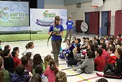 Earth Rangers presenter showing elementary students a tegu