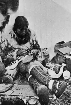Making waterproof summer overshoes in a tent,[4] c. 1900, Port Clarence, Alaska