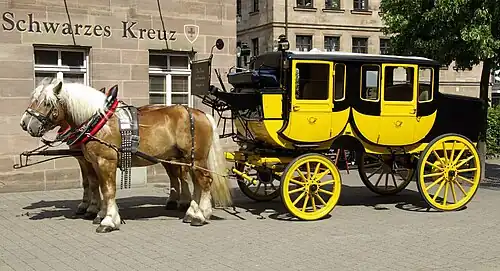 Pair of Rhenish German Coldbloods hitched to a mail coach