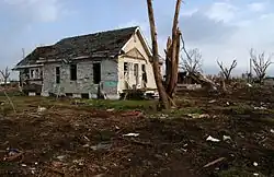 A home that was hit by the tornado. While not completely destroyed, shingles and parts of the walls are missing.