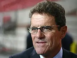 A head-shot of a brown-haired man in his sixties. He has blue eyes and is wearing glasses.
