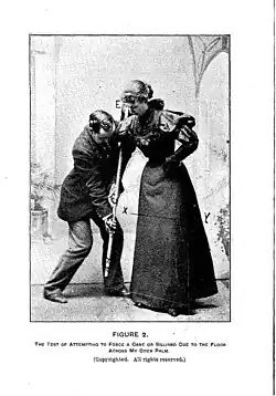 A person holds the cue or cane with their body weight and Hurst places rest an open palm against its underside between his hands.