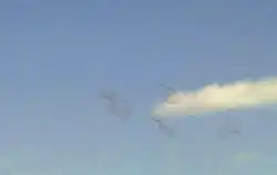 Floaters against a blue sky with cloud.