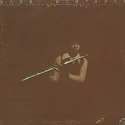 A photo of the artist holding her flute.