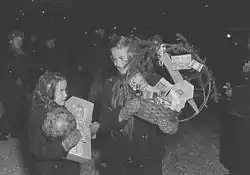 Photograph of two girls holding gifts