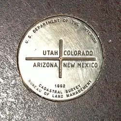 A metal disk reading "U.S. Department of the Interior – Utah, Colorado, Arizona, New Mexico – 1992 – Cadastral Survey – Bureau of Land Management"