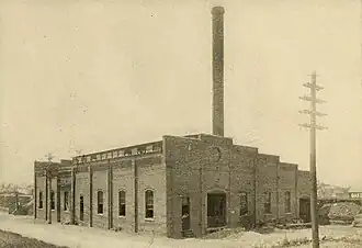 A one-story brick powerhouse with a chimney