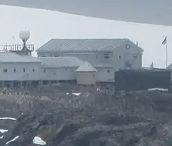 A small wooden structure next to several grey buildings