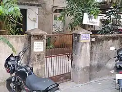 Gate to a building with signboard of the address and residents